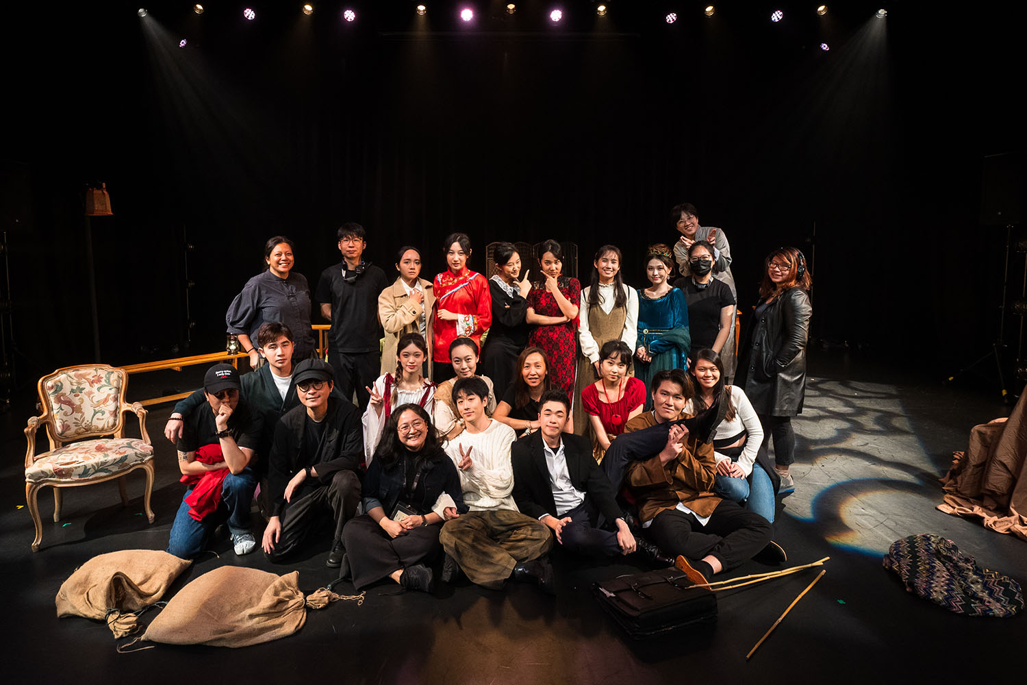 Various performers, taking a group photo together on-stage.