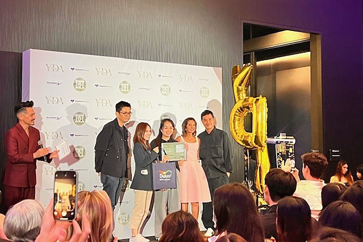 Another group photo at Young Designer Award 2024. A smaller group of recipients holding various awards.