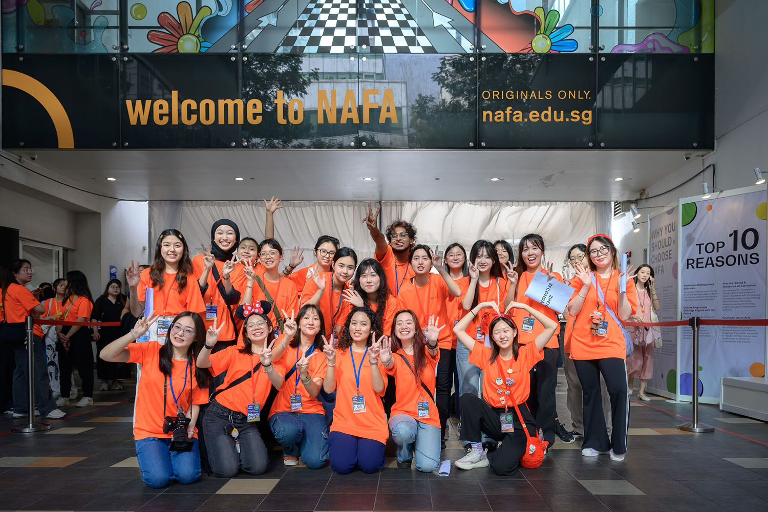 Group photo of volunteers in orange t-shirts at the NAFA Open House event.