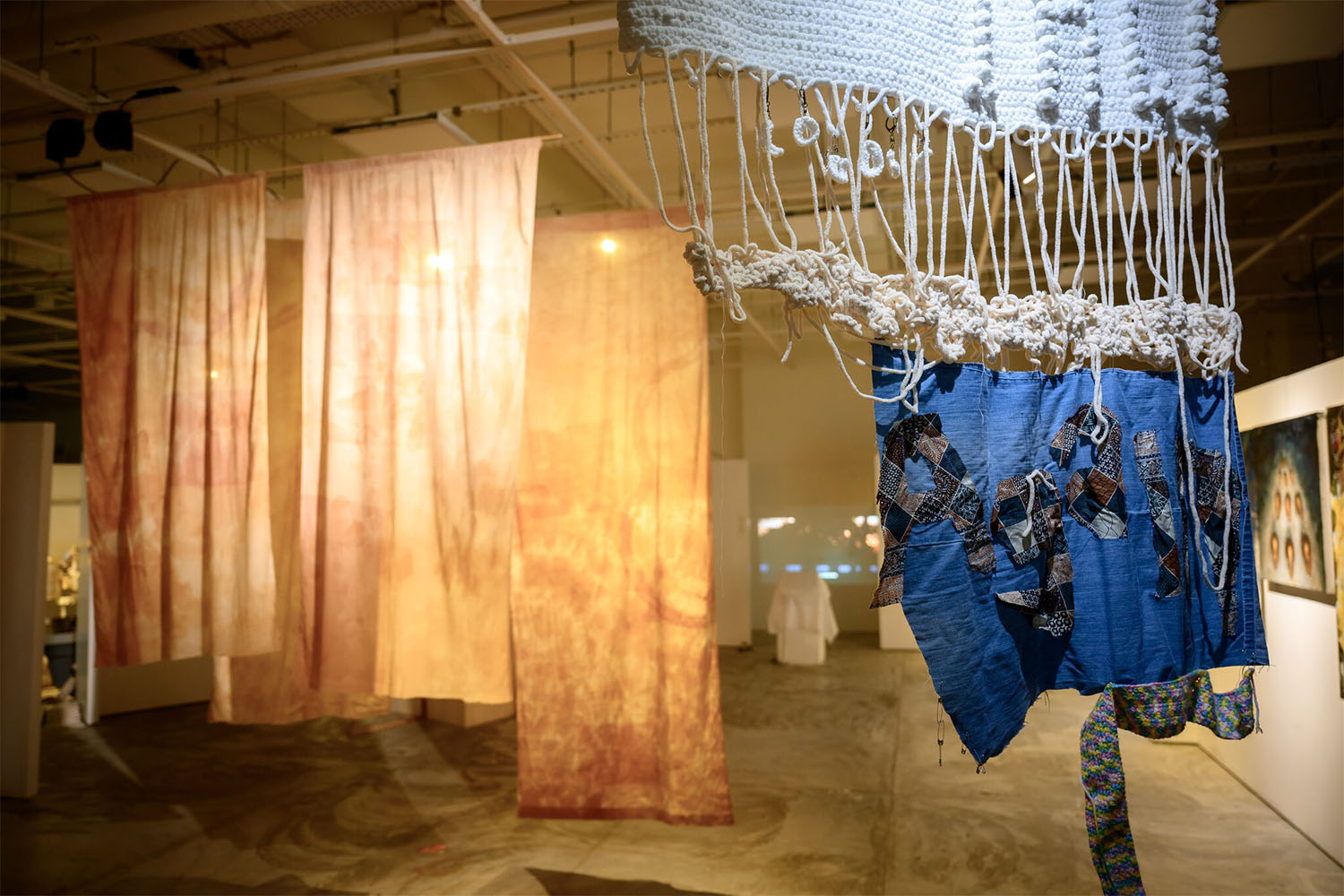 Installation art featuring hanging fabrics on drapes.