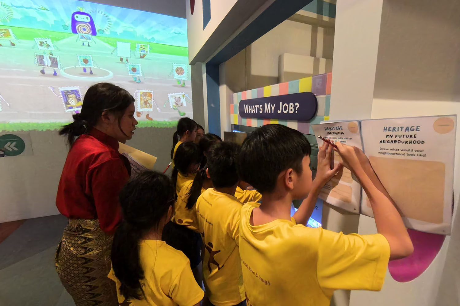 Various children and a guidesperson at the Heritage My Future Neighbourhood exhibition.
