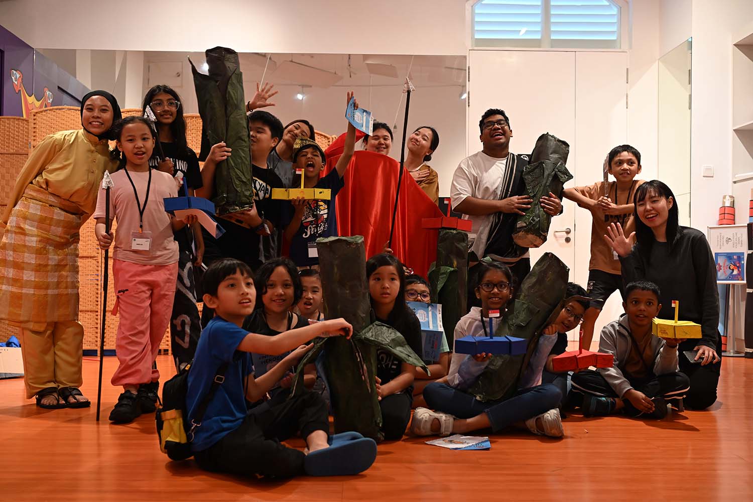 Various people - adolescents, kids, young adults, with various props from the Childrens Museum.