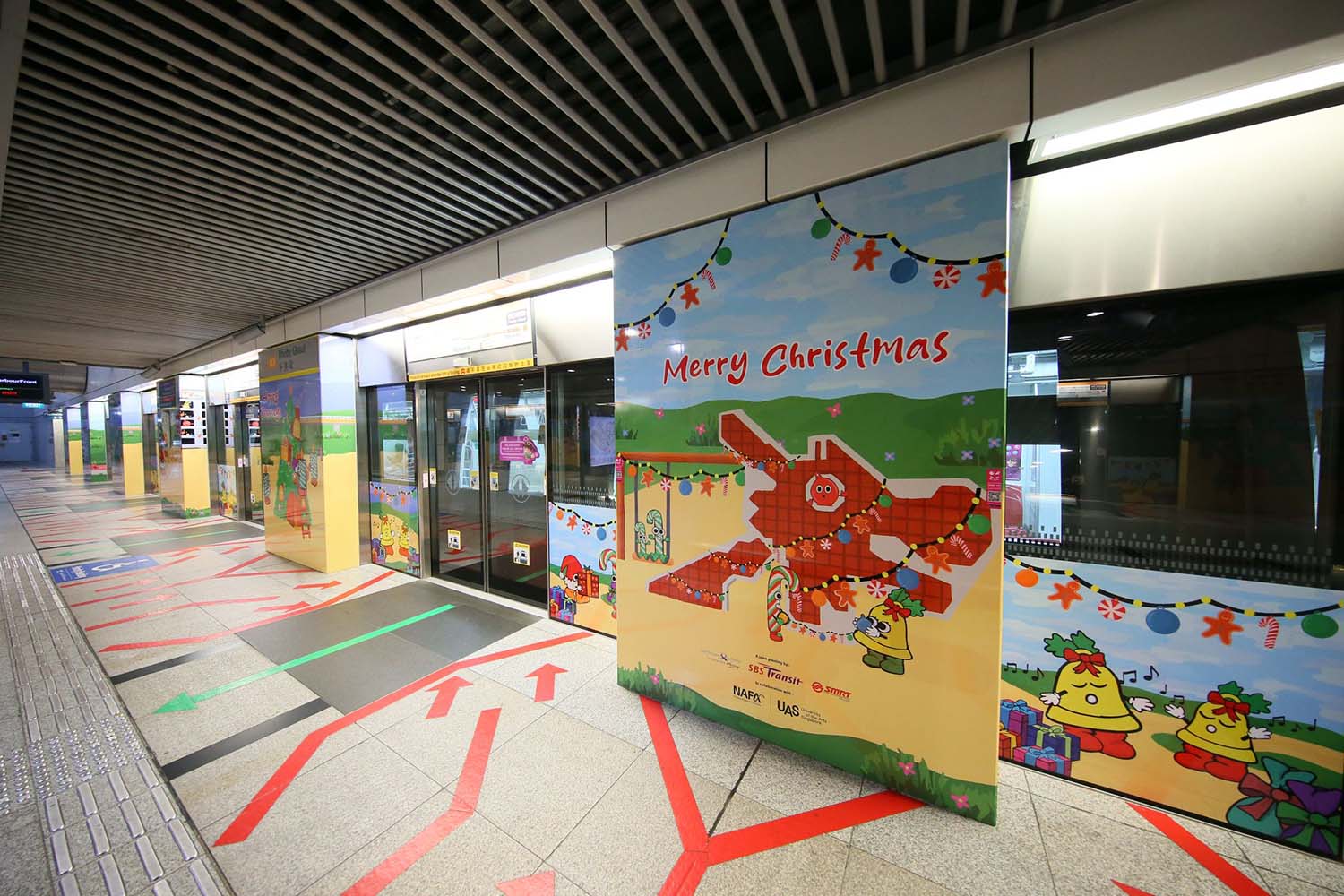 Angled side view of a MRT entrance slide door, decorated with Christmas festive illustrations and depicting a Singapore dragon playground.