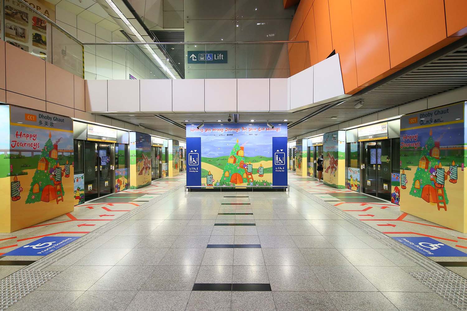 Single-point perspective straight view of various MRT entrance slide doors and panels, the front being the exterior of the elevator tower, all decorated with cartoony Christmas festive illustrations.